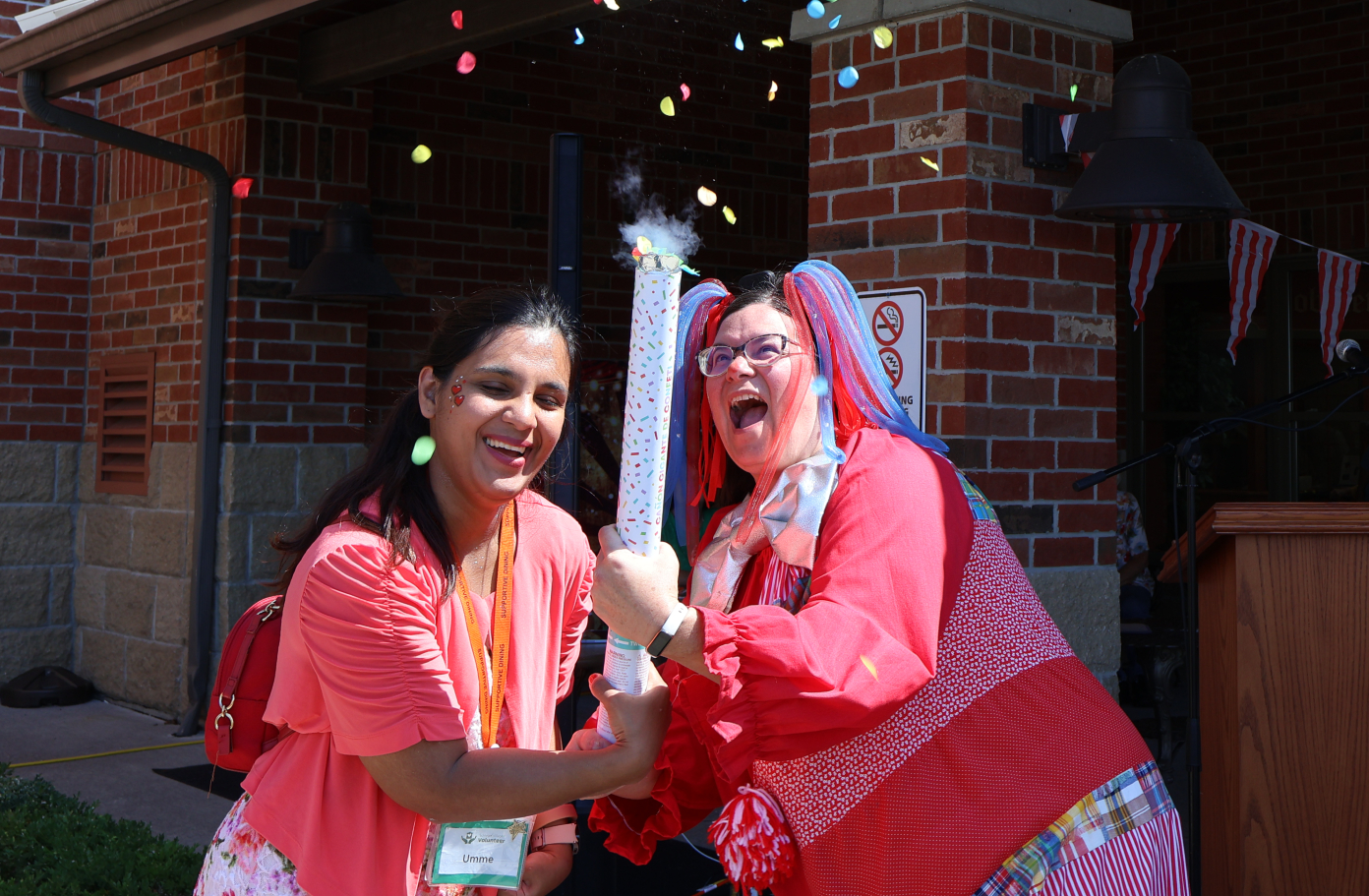 Recreation director Hannah and volunteer Umme light off a confetti canon during the 10th anniversary celebrations at The Village at St. Clair. 