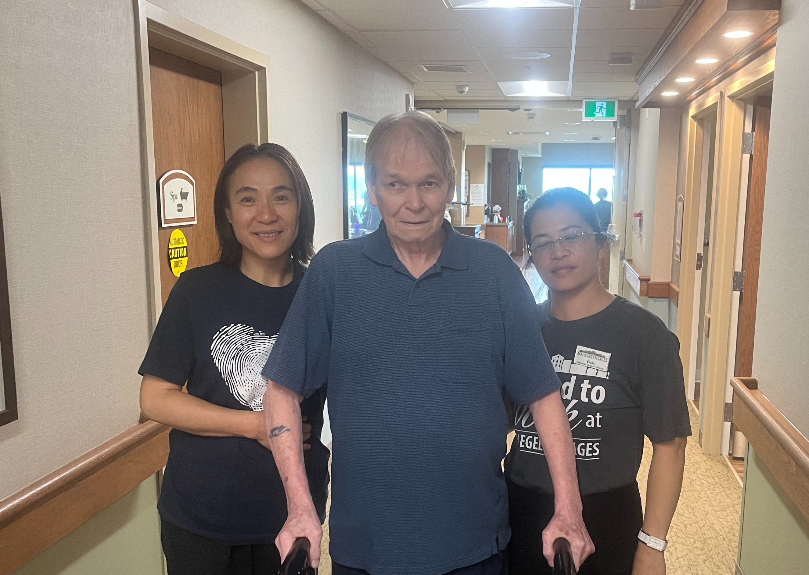 Harry stands with two of the team members he says have been critical in helping him regain his strength and independence. 