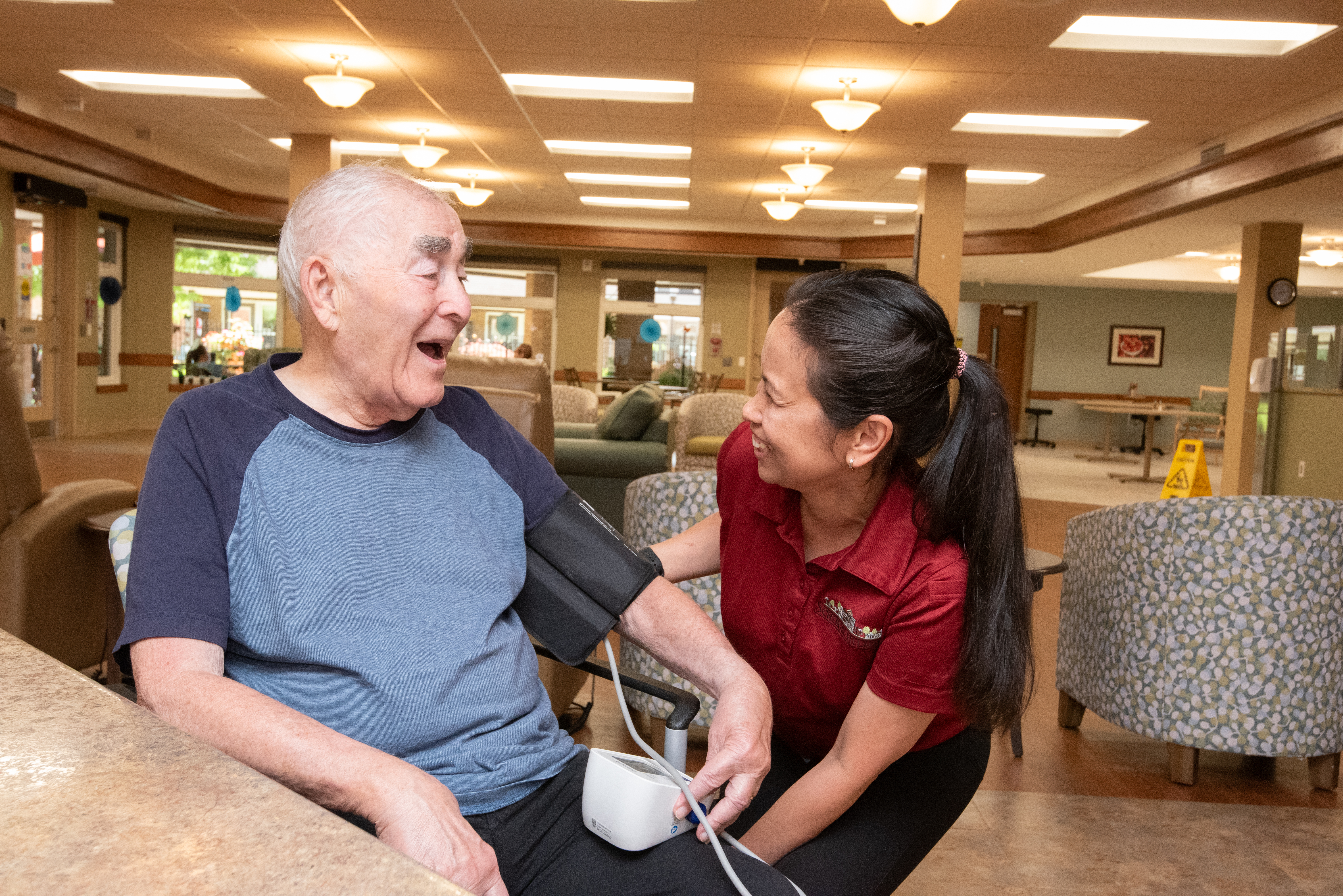 A team member and resident share laughter together while sitting in one of the Schlegel Villages neighbourhoods.