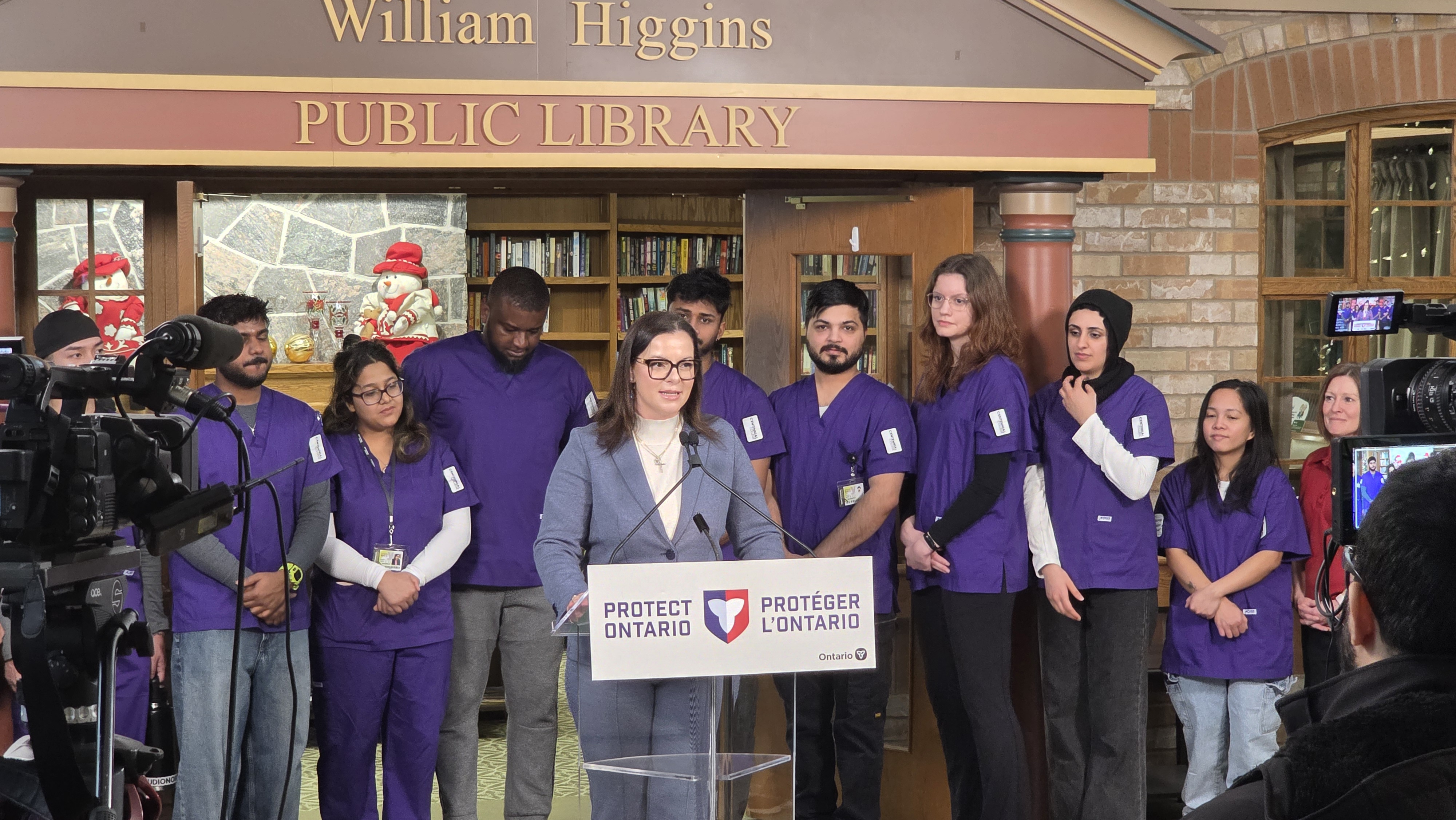 Minister Kusendova-Bashta stands with Centennial College students during an announcement at The Village of Taunton Mills. 