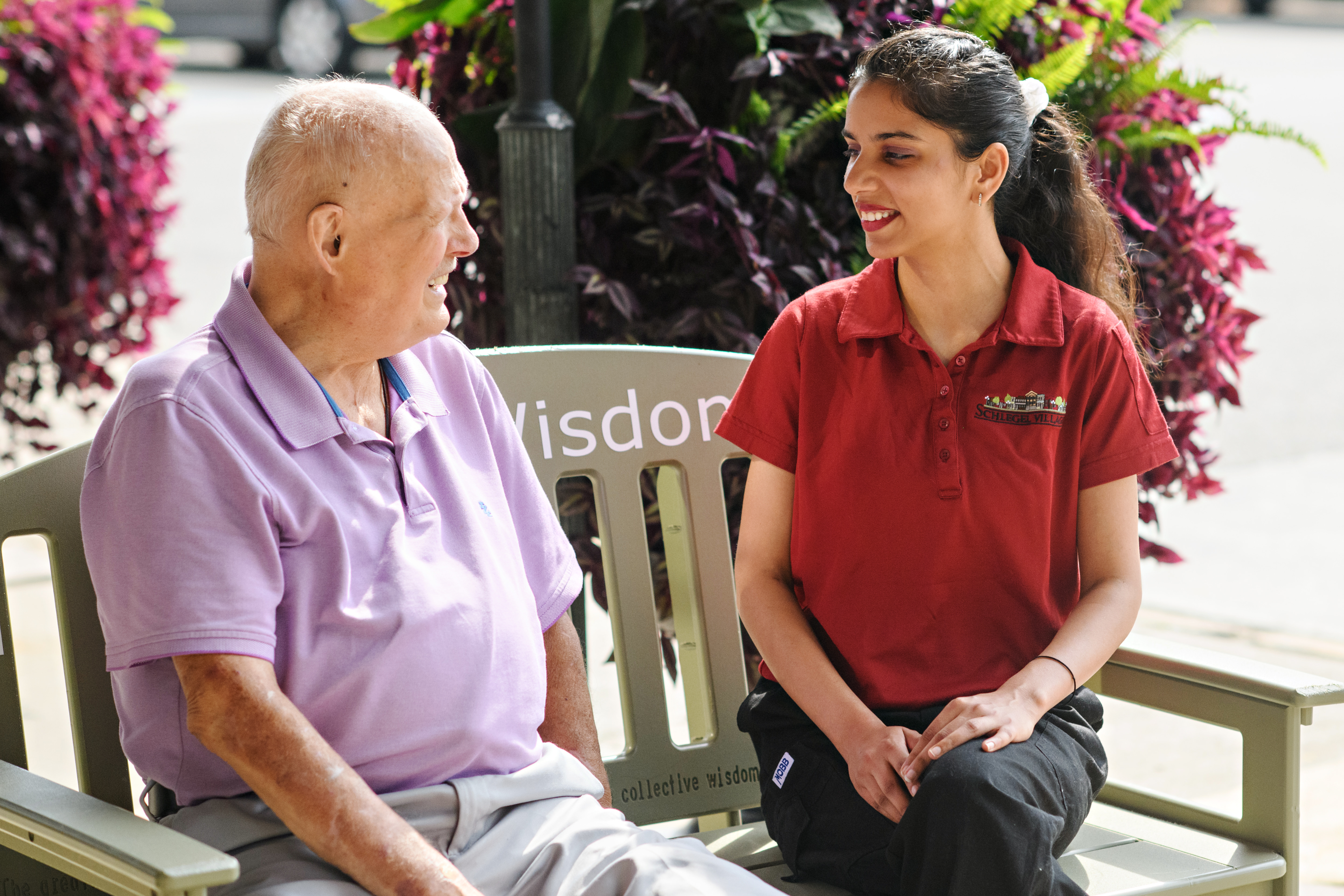 Ron Schlegel sits upon the Green Bench with a team member.