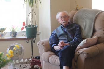 Bill sitting in an arm chair in his suite