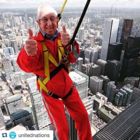 Ted Woodley giving the thumbs up as he leans backwards at the top of the CN Tower
