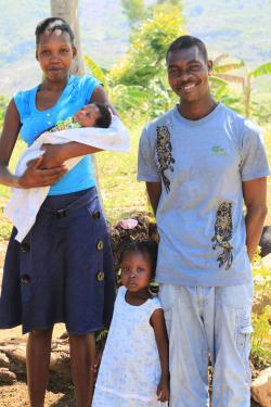 Young Haitian family with a mother holding a baby, a young man, and a toddler