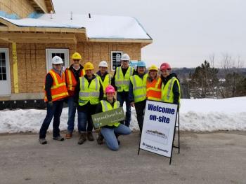 Team members gather outside of the construction site for a photo.