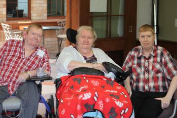 Residents Jack, Carrie, and Robert pose for a group photo within Sandalwood Park