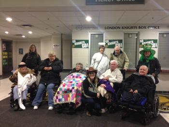 Group of residents and team members bundled up n a hockey arena waiting area