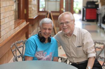 Bebe with headphones around her neck posing for a photo with Ken